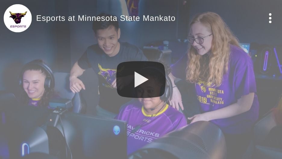 Video thumbnail showing students gathered in the Esports Training Facility gaming on PCs. Video play button in the middle of the image and Maverick Esports logo in the top corner.