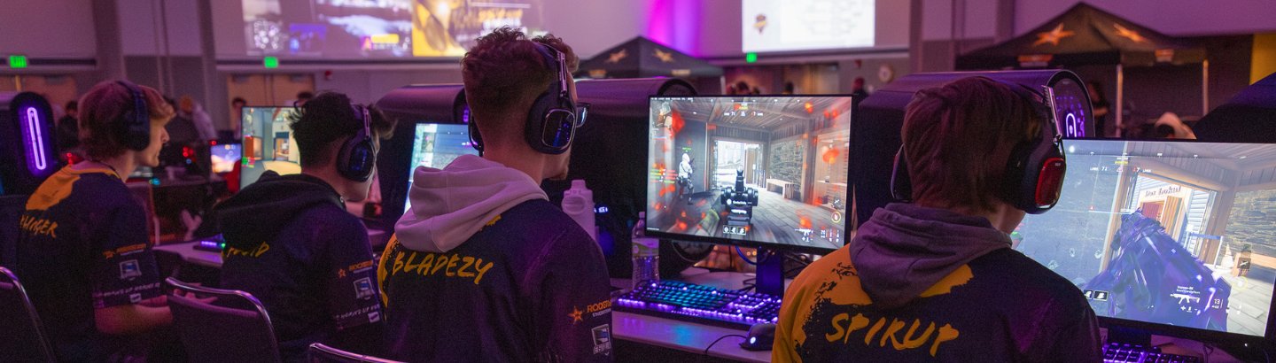 Varsity call of duty team playing in front of screen in rockstar invitational event