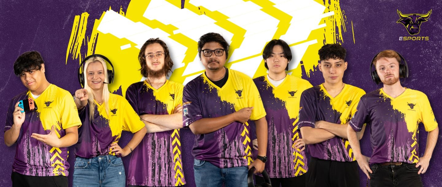 Several varsity esports players standing in a line with different poses, all wearing purple and gold Maverick Esports jerseys. Maverick Esports logo in the corner.